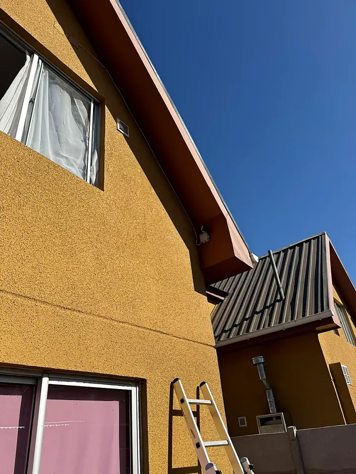 Casa de dos pisos con una cámara en el alero y la escalera usada en la instalación