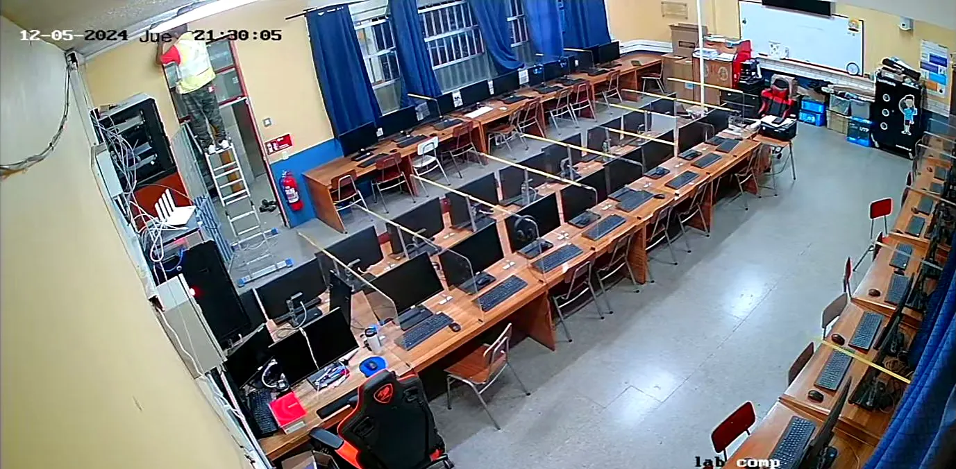 Vista de una cámara instalada en una sala de computación, con un técnico trabajando en altura