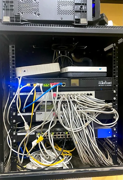 Rack antes: switches y router con cables sueltos y enredados